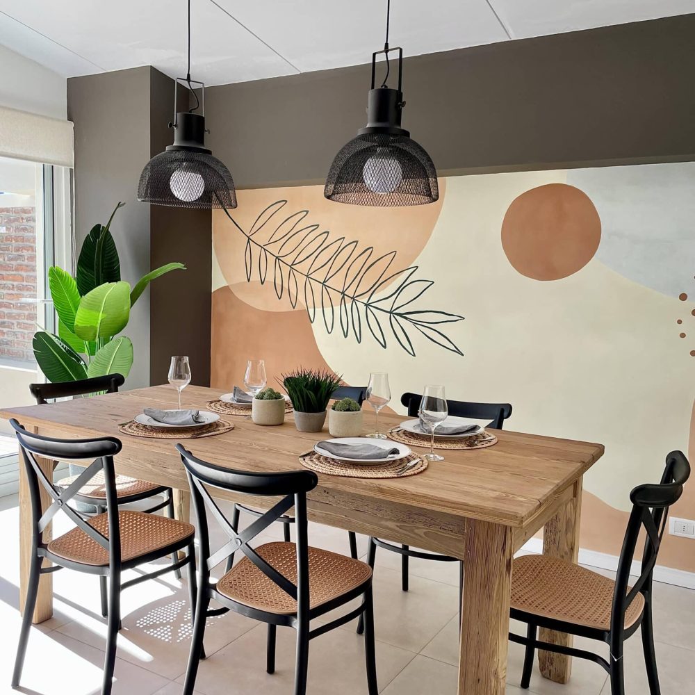 Proyecto de diseño de cocina y Comedor en Haras del Lago, un barrio cerrado en Canelones, Uruguay. La cocina presenta muebles en acabado maderado, un tablero negro antihuella y mesadas de granito negro absoluto, combinando elegancia y funcionalidad.