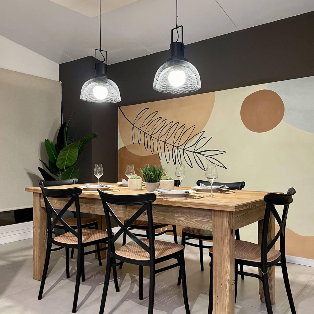 Proyecto de diseño de cocina y comedor en Haras del Lago, un barrio cerrado en Canelones, Uruguay. La cocina presenta muebles en acabado maderado, un tablero negro antihuella y mesadas de granito negro absoluto, combinando elegancia y funcionalidad.