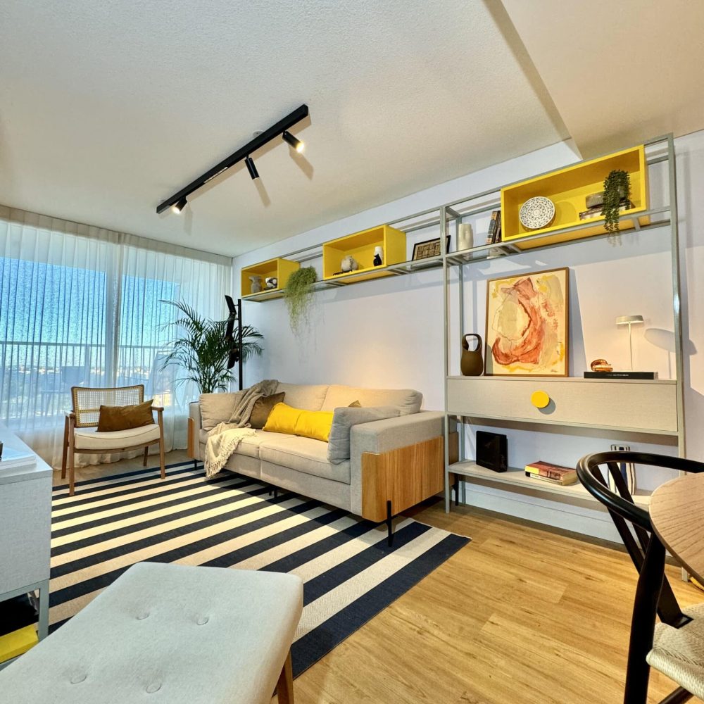 Transformación de living comedor en Malvín por Estudio Welfare, estudio de diseño de interiores en Montevideo. Este diseño de interiores en Malvín utiliza colores de acento para crear contraste y dinamismo en un espacio moderno y fresco. La sala de estar y el comedor destacan por su iluminación cálida y ajustable, ideal para diferentes actividades. Un ejemplo perfecto de diseño de espacios pequeños, combinando funcionalidad y estética con materiales naturales y acentos contemporáneos. Estudio Welfare trabaja en Montevideo y en todo el país, creando ambientes que mejoran la calidad de vida.