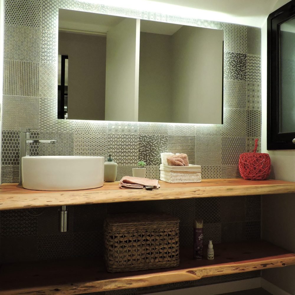 Descubre la elegancia y la funcionalidad en nuestro baño de servicio bajo la escalera. Con un diseño que prioriza la armonía y la originalidad, este espacio presenta un patchwork de cerámica en tonos grises, un espejo iluminado y una mesada de madera natural con una bacha de sobreponer circular y una canilla en acero inoxidable. Cada detalle contribuye a crear un ambiente único y acogedor, donde la serenidad y la tranquilidad están en primer plano