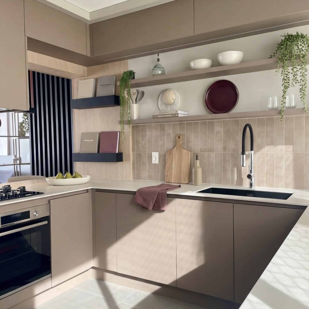 Vista frontal de cocina reformada con mobiliario Cappuccino, Carvalho Natural y estanterías decorativas.