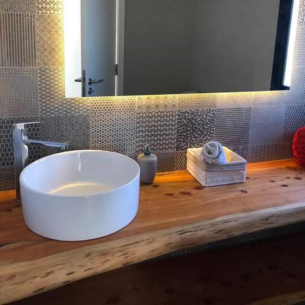 Descubre la elegancia y la funcionalidad en nuestro baño de servicio bajo la escalera. Con un diseño que prioriza la armonía y la originalidad, este espacio presenta un patchwork de cerámica en tonos grises, un espejo iluminado y una mesada de madera natural con una bacha de sobreponer circular y una canilla en acero inoxidable. Cada detalle contribuye a crear un ambiente único y acogedor, donde la serenidad y la tranquilidad están en primer plano