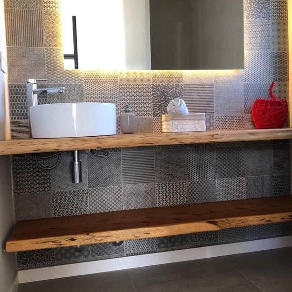 Descubre la elegancia y la funcionalidad en nuestro baño de servicio bajo la escalera. Con un diseño que prioriza la armonía y la originalidad, este espacio presenta un patchwork de cerámica en tonos grises, un espejo iluminado y una mesada de madera natural con una bacha de sobreponer circular y una canilla en acero inoxidable. Cada detalle contribuye a crear un ambiente único y acogedor, donde la serenidad y la tranquilidad están en primer plano
